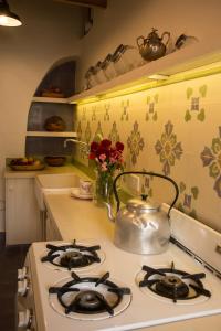 乌玛瓦卡切洛阿里巴度假屋的厨房配有炉灶和茶壶