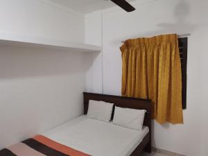 贾夫纳纳鲁尔假日旅馆的黄色窗帘的房间的一张床位