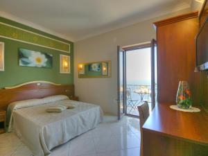 康加德马里尼伊尔帕沃食宿酒店的一间带一张床和一张书桌的卧室以及一个阳台