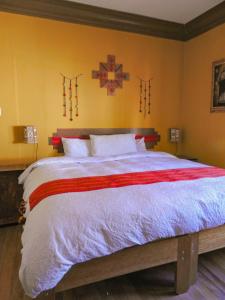 库斯科CASA HOSPEDAJE EL LABRADOR的卧室配有一张大床,墙上有十字架