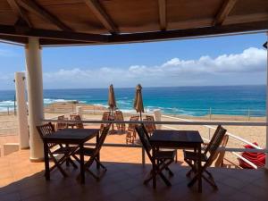 Calheta Do MaioCosy & Relax Yellow House 5mn walk from the beach!的一个带桌子和遮阳伞的庭院和大海