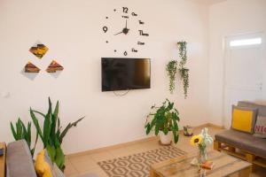 Calheta Do MaioCosy & Relax Yellow House 5mn walk from the beach!的客厅配有沙发和墙上的时钟