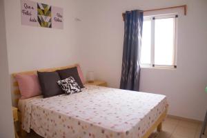 Calheta Do MaioCosy & Relax Yellow House 5mn walk from the beach!的一间卧室设有一张大床和窗户