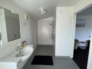 布伦海姆克罗尼尔汽车旅馆的白色的浴室设有水槽和淋浴。