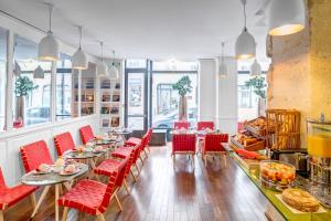 巴黎阿斯托利亚蒙泰罗萨酒店的餐厅设有红色的椅子和桌子以及窗户。