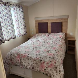 斯凯格内斯4 BEDROOMS CARAVAN at Waterside Leisure Holiday Park的一间卧室配有一张带花卉床罩的大床