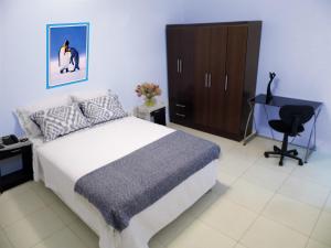 特鲁希略Magicperu Apart Hotel的一间卧室配有一张床、一张桌子和一把椅子