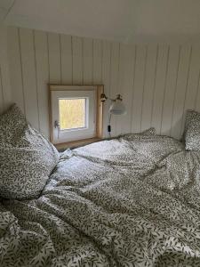 格林斯泰兹Kroghs Tiny Houses - Hyttebyen的一间卧室设有一张床和一个窗口
