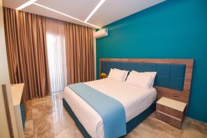 都拉斯Hotel Vivas的一间卧室设有一张蓝色墙壁的大床