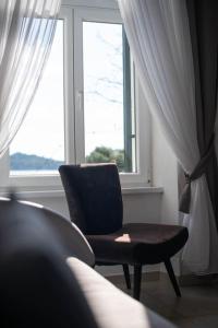 希贝尼克Apartment Val with sea view的坐在窗前的椅子