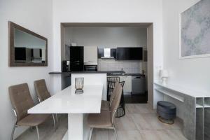 希贝尼克Apartment Val with sea view的厨房以及带白色桌椅的用餐室。