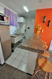 福塔莱萨Apartamento na Praia de Iracema, Meireles.的厨房配有柜台、冰箱和椅子