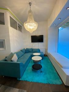 柏林City-Apartment II Kreuzberg的客厅配有蓝色的沙发和吊灯。