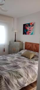 萨拉戈萨Suite Lay的卧室内的一张床铺,墙上有绘画作品