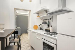 卡塔尼亚Residenze Florio的厨房配有白色的柜台和炉灶烤箱。