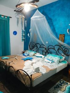 米利纳Athina-Milina的一间卧室配有一张蓝色墙壁的床