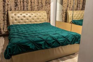 锡盖图马尔马切伊Pensiunea Brezu的一张带绿色被子和镜子的床
