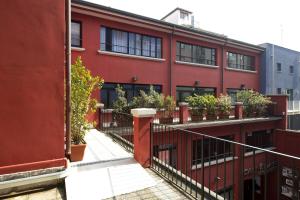 米兰Oasi Village Hotel的阳台上的红色建筑,种植了盆栽植物