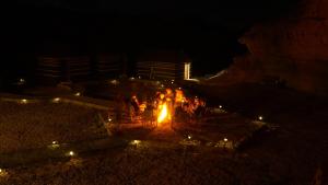瓦迪拉姆Desert Jewel Camp的一群人晚上在火堆旁