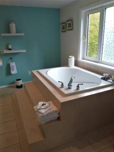 彻梅纳斯By the Bay Lavender Villa的带窗户的浴室设有大浴缸