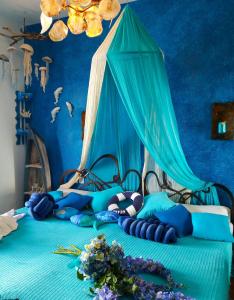 米利纳Athina-Milina的蓝色卧室,配有一张带天蓬的床