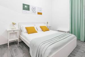 米兰拉福尔泰扎公寓的卧室内的白色床和黄色枕头