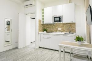 米兰拉福尔泰扎公寓的厨房配有白色橱柜和桌子