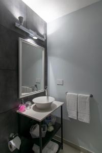 罗萨里奥Franca Estadías Temporarias的浴室配有盥洗盆、镜子和毛巾