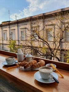 罗萨里奥Franca Estadías Temporarias的阳台上的桌子上放着羊角面包和咖啡