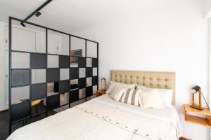 罗萨里奥Franca Estadías Temporarias的一间卧室配有一张大床,配有黑白床头板