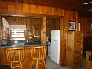 Glenhaven湖泊广场度假酒店的厨房配有白色冰箱和木墙