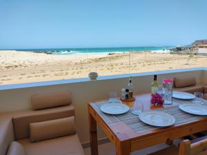 萨尔雷Terra Kriola的一张桌子,上面放有盘子和瓶装葡萄酒,还有沙滩