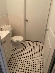纽波特monthly only shared apt的一间带卫生间的浴室以及黑色和白色的瓷砖地板。