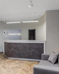 基辅HAMSTER APART的一间配有沙发的等候室和墙上的标志
