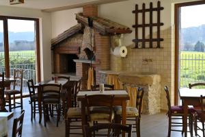 古比奥Agriturismo A Casa Mia Gubbio的一间带桌子和砖砌壁炉的用餐室