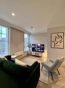 莱瑟姆-圣安妮The Apartments Lytham Square的客厅配有绿色沙发和电视
