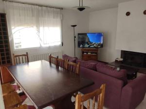 CirueñaLa casa de la Plaza - WIFI - Barbacoa - Chimenea的客厅配有桌子和紫色沙发