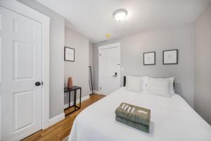 波士顿4BR1BTH South Boston Apt perfect for commutes的卧室配有白色的床和白色门