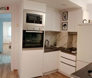 萨拉戈萨Suite Lay的厨房配有白色橱柜和微波炉