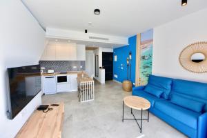 科蒂略LACASA Apartments Cotillo的一间带蓝色沙发的客厅和一间厨房