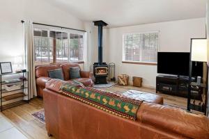 本德Indio Cabin的客厅配有真皮沙发和木柴炉。