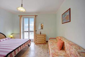 圣巴特罗摩艾美尔Il Poggio di Poiolo的一间卧室配有一张床、一张沙发和一个窗口