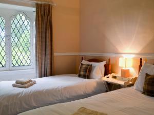 Belladrum达夫斯旅馆 - 博福特庄园 的带窗户的客房内的两张床