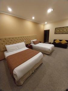 昆卡卡瓦洛酒店的酒店客房,设有两张床和一张沙发