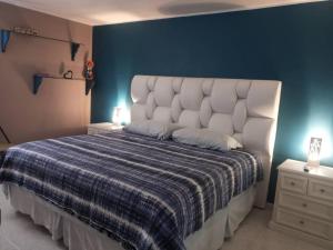 加拉加斯CALIFORNIA SUITE的一间卧室设有一张蓝色墙壁的大床
