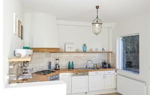 滨海贝亨Nautilus 1的白色的厨房设有水槽和炉灶。