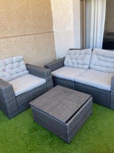 萨伊迪耶Appartement de LUXE Marina SAIDIA avec vue sur PISCINE Résidence TAMARIS的三个柳条椅和沙发坐在草地上