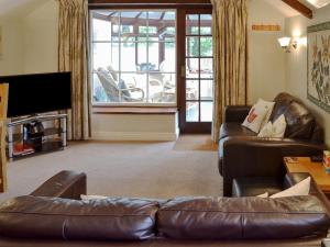HalwellGarden Cottage - Cp28的客厅配有真皮沙发和电视