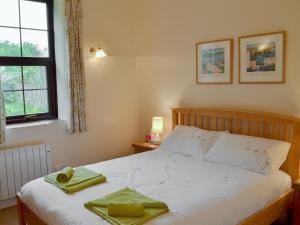 HalwellGarden Cottage - Cp28的一间卧室配有一张床,上面有两条毛巾