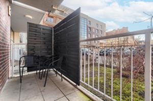 什切青EXCLUSIVE New Town Apartments的阳台设有黑色围栏和桌椅。